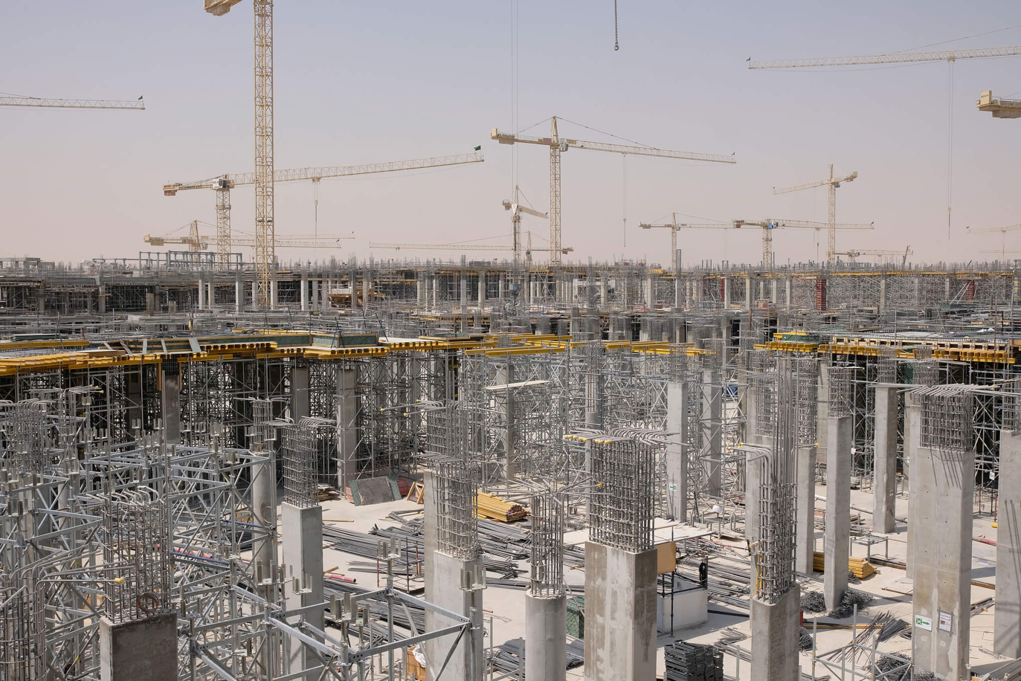 Tower cranes and concrete columns rising on a large construction site